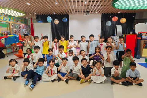 穿著小學校服的畢業生在幼稚園禮堂內合照