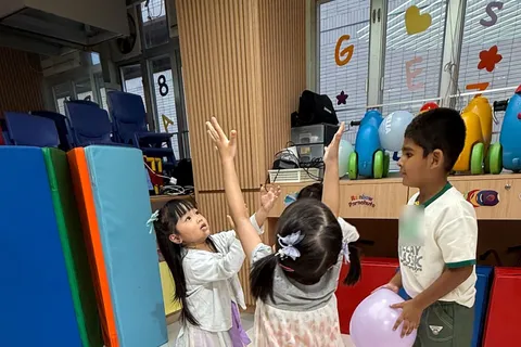 小朋友伸手把氣球拍向空中