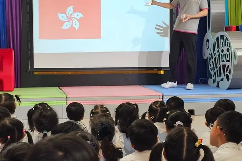 老師在國慶集會上向小朋友介紹香港區旗