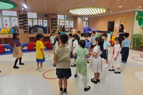 畢業生在幼稚園禮堂內一起玩呼拉圈遊戲