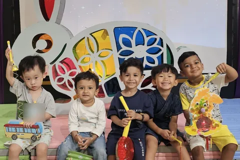 K1B 班的五位男孩提著花燈，在中秋節慶祝活動的兔子花燈舞台佈景前合照
