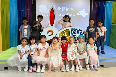 K3R 班的小朋友在中秋節慶祝活動的兔子花燈舞台佈景前合照