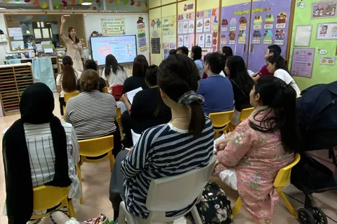 家長觀看老師講解「鼓勵孩子思考」策略的簡報